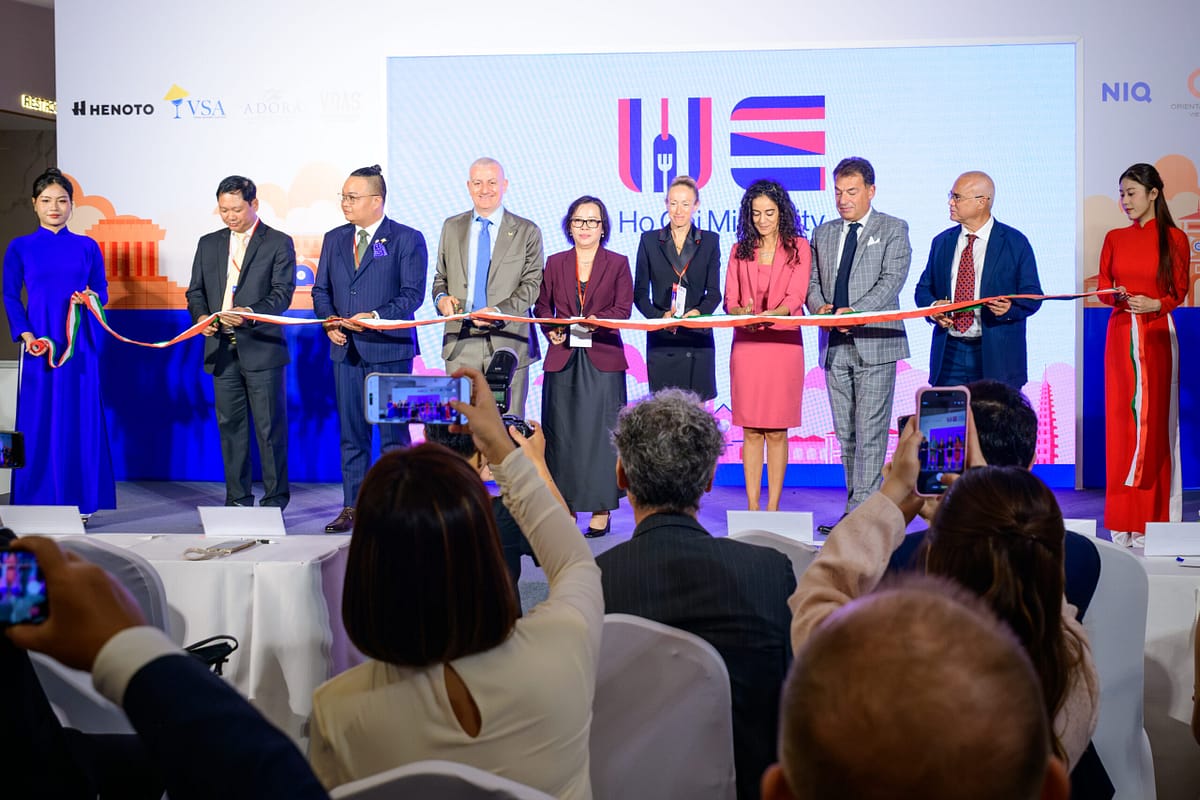 Ribbon-cutting ceremony at Wines Experience HCMC 2026, with HENOTO, Vietnam Sommelier Association and ADORA logos in the backdrop
