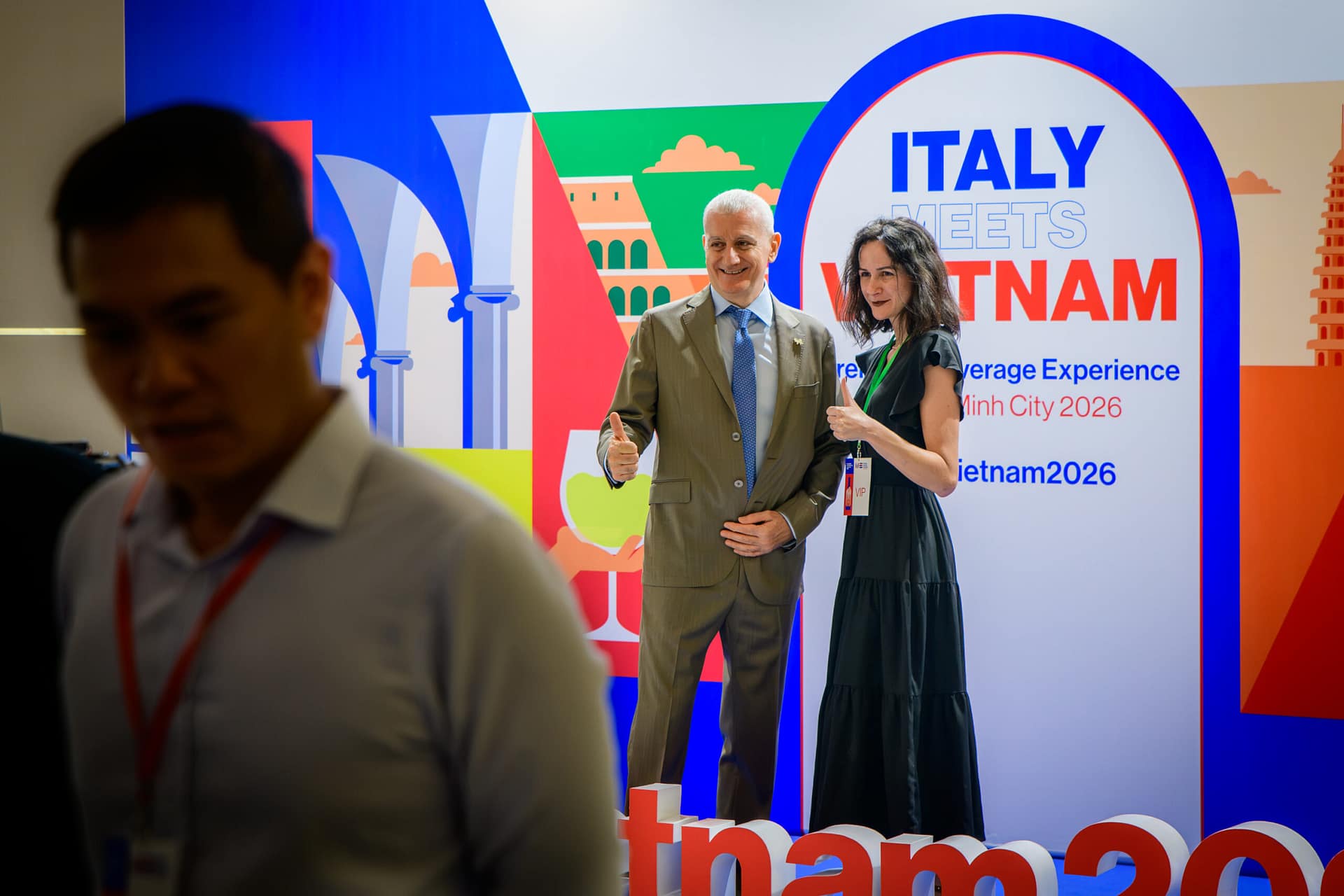 Attendees posing in front of the Italy Meets Vietnam Premium Beverage Experience backdrop at Wines Experience Ho Chi Minh City 2026