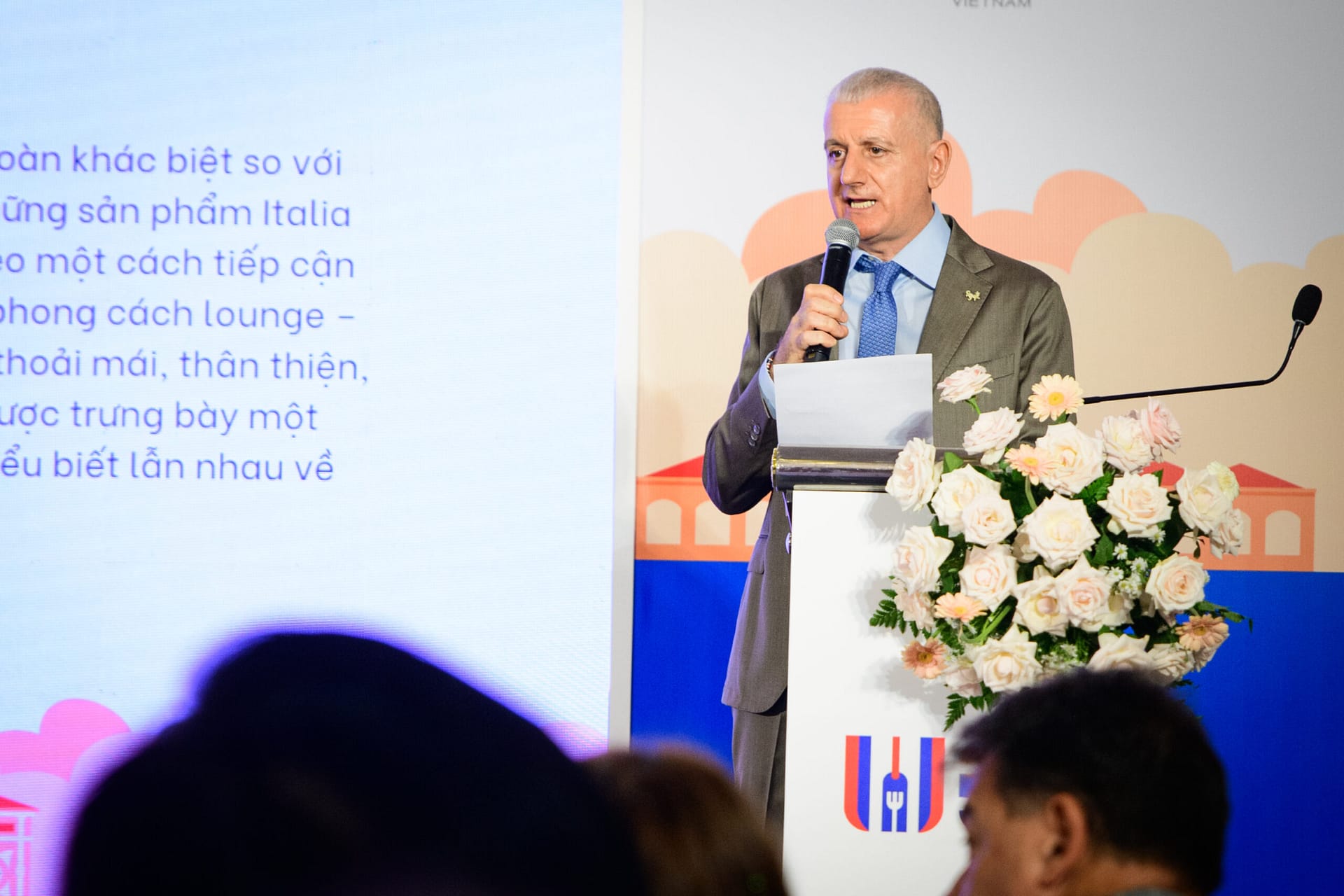 Italian official delivering remarks at the opening ceremony podium of Wines Experience Ho Chi Minh City 2026
